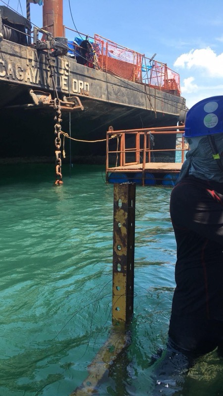 Diver at piling with vessel name visible